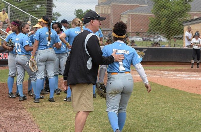 This is an image of Coach John Garris offering advice to one of his players, while walking to join a gathering of the entire team on the softball field. Our founder is the basis that we have built College Camp Consulting on with great camp solutions.